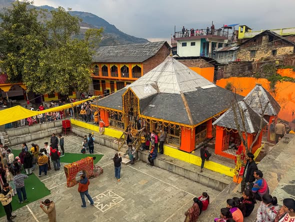 Ancient Pahari temple courtyard with carved wood pagoda roof in Saal Valley, Chamba