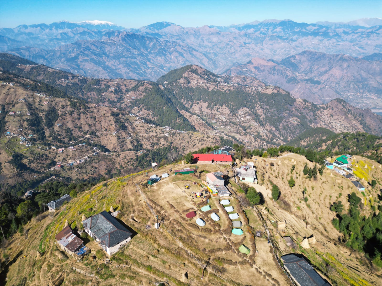 Aerial vista of a Khajjiar ridge hamlet with community campsite and Himalayan slopes, Chamba