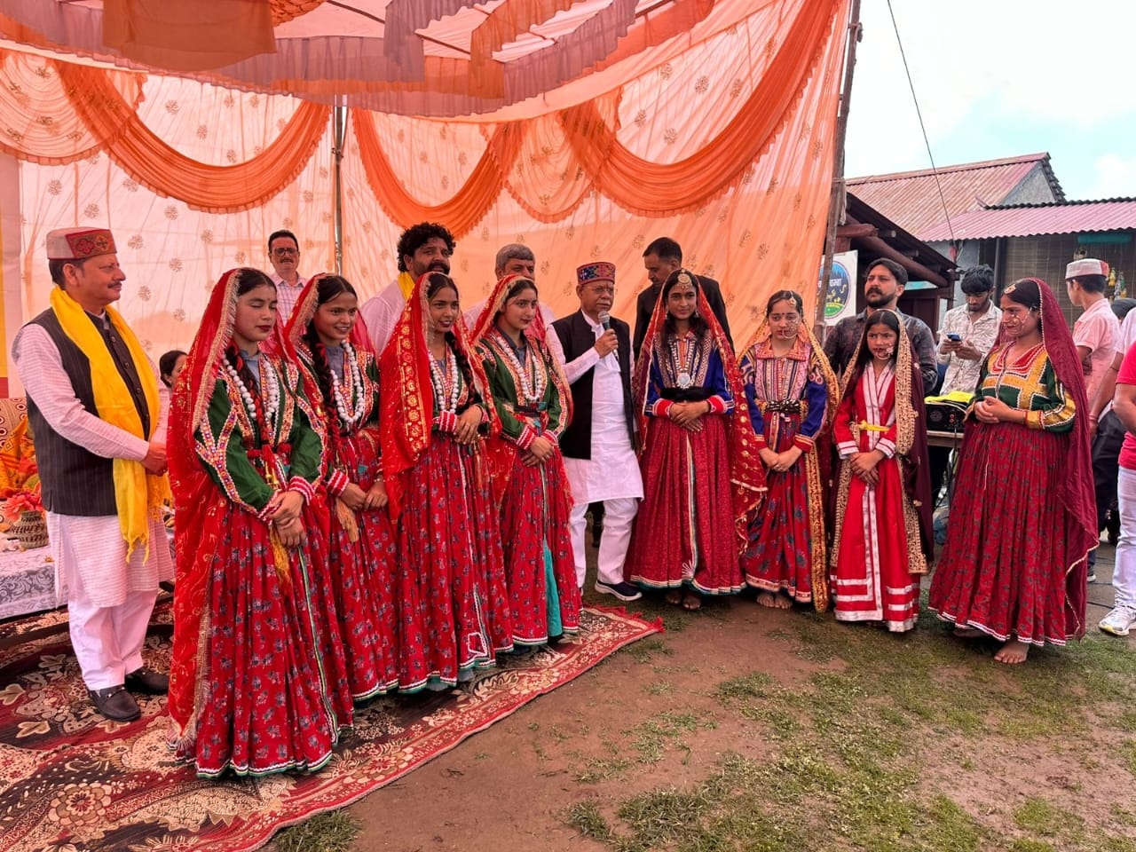 Young women in traditional Chambyali red attire at a Mystic Village cultural gathering, Khajjiar cluster, Chamba