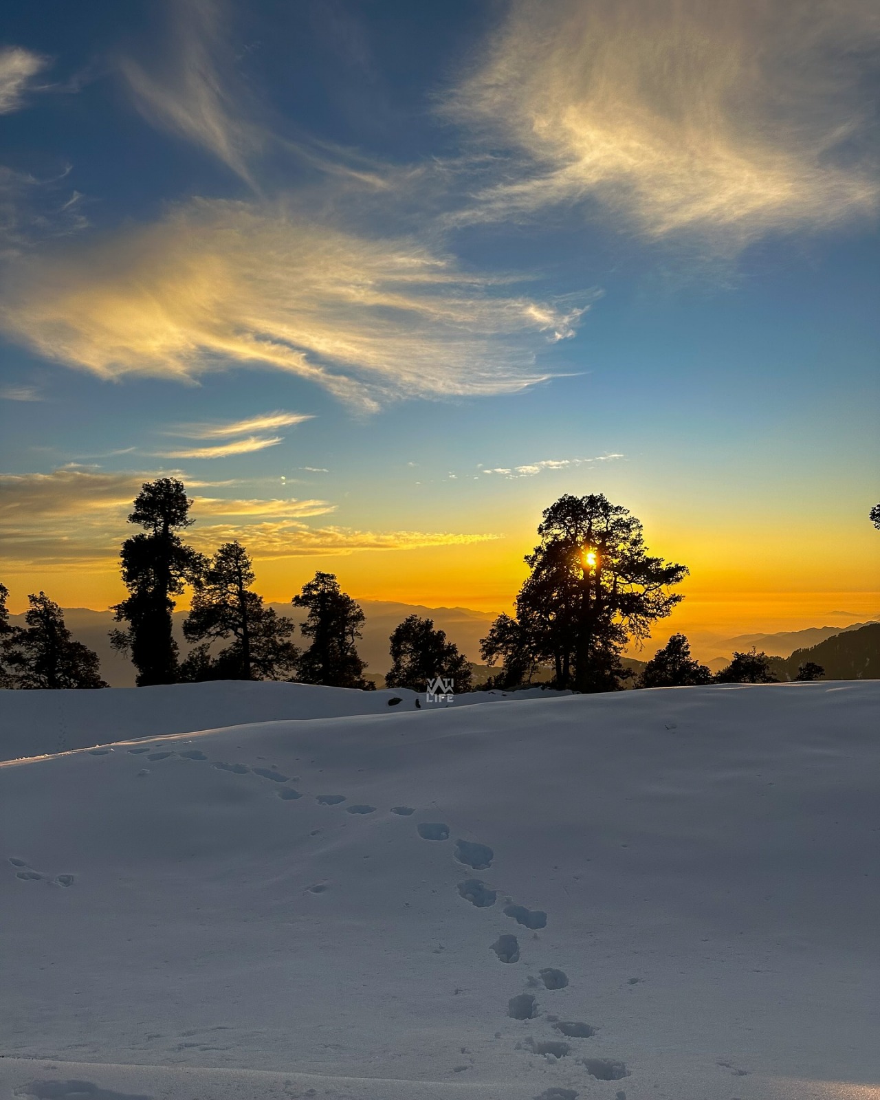 Footprints in fresh snow at sunrise over Saal Valley ridgeline, Chamba Himalayas