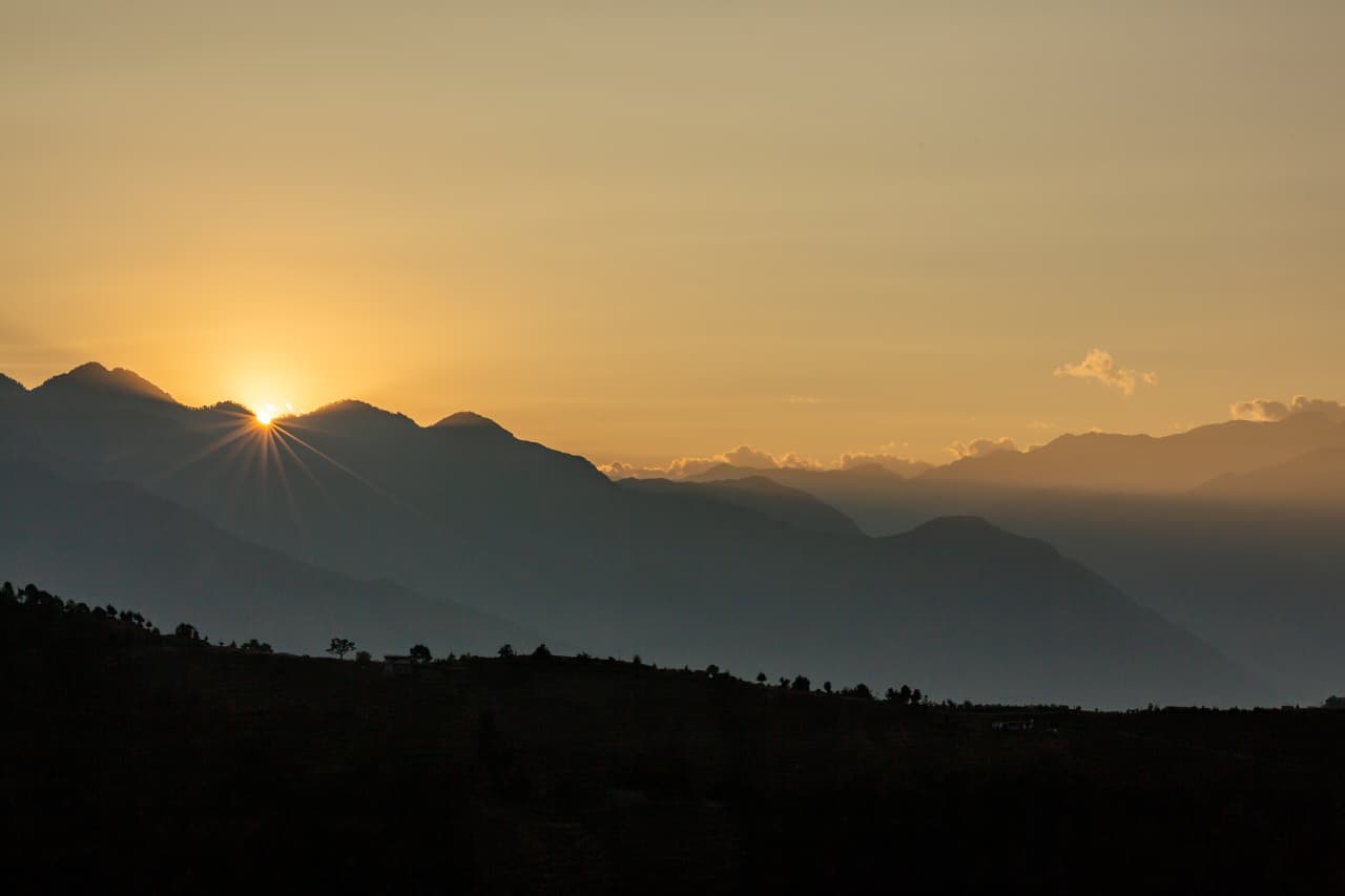 Golden sunrise behind Pir Panjal ridges seen from a Khajjiar-cluster viewpoint, Chamba
